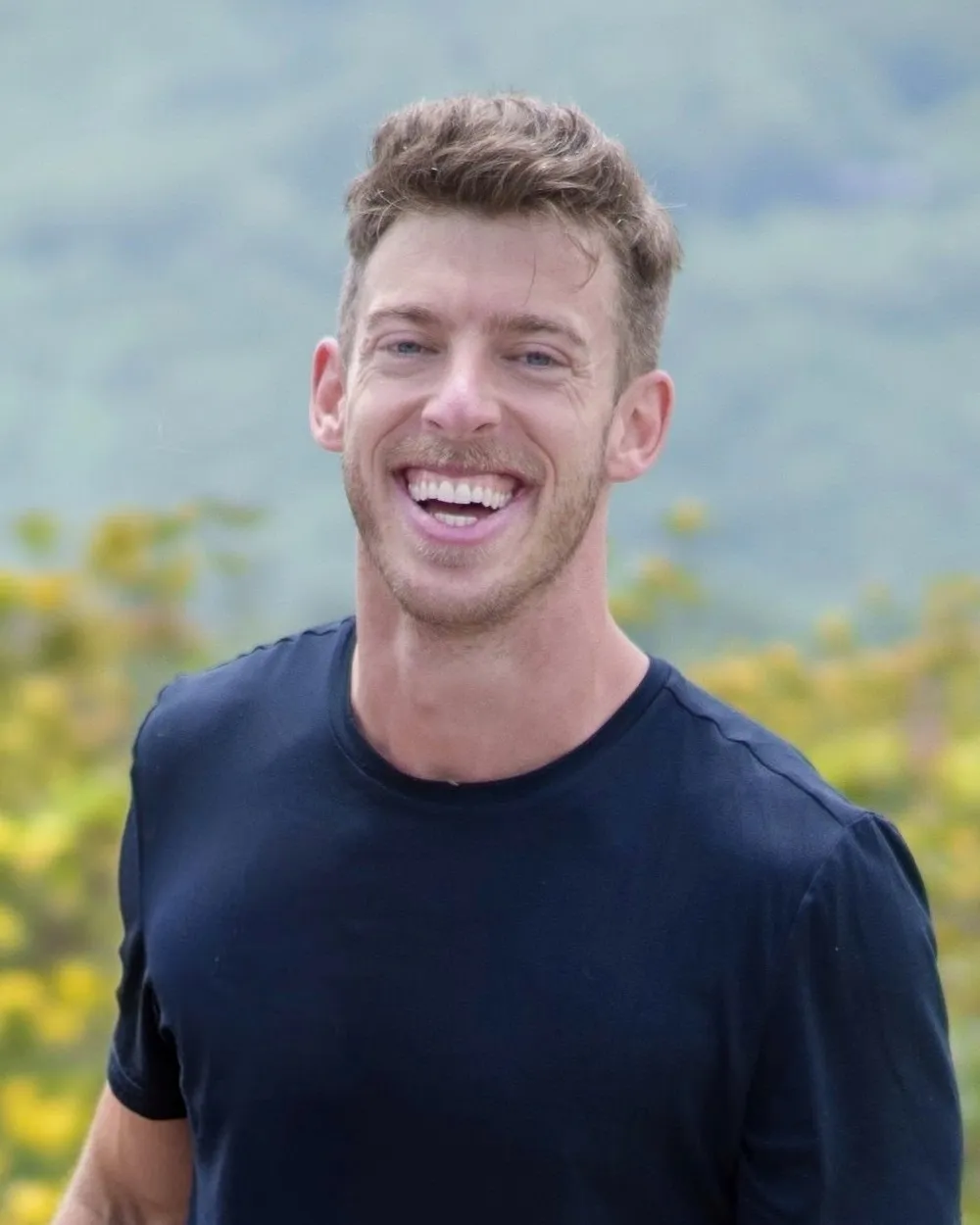 James Christensen, laughing, in a navy t-shirt